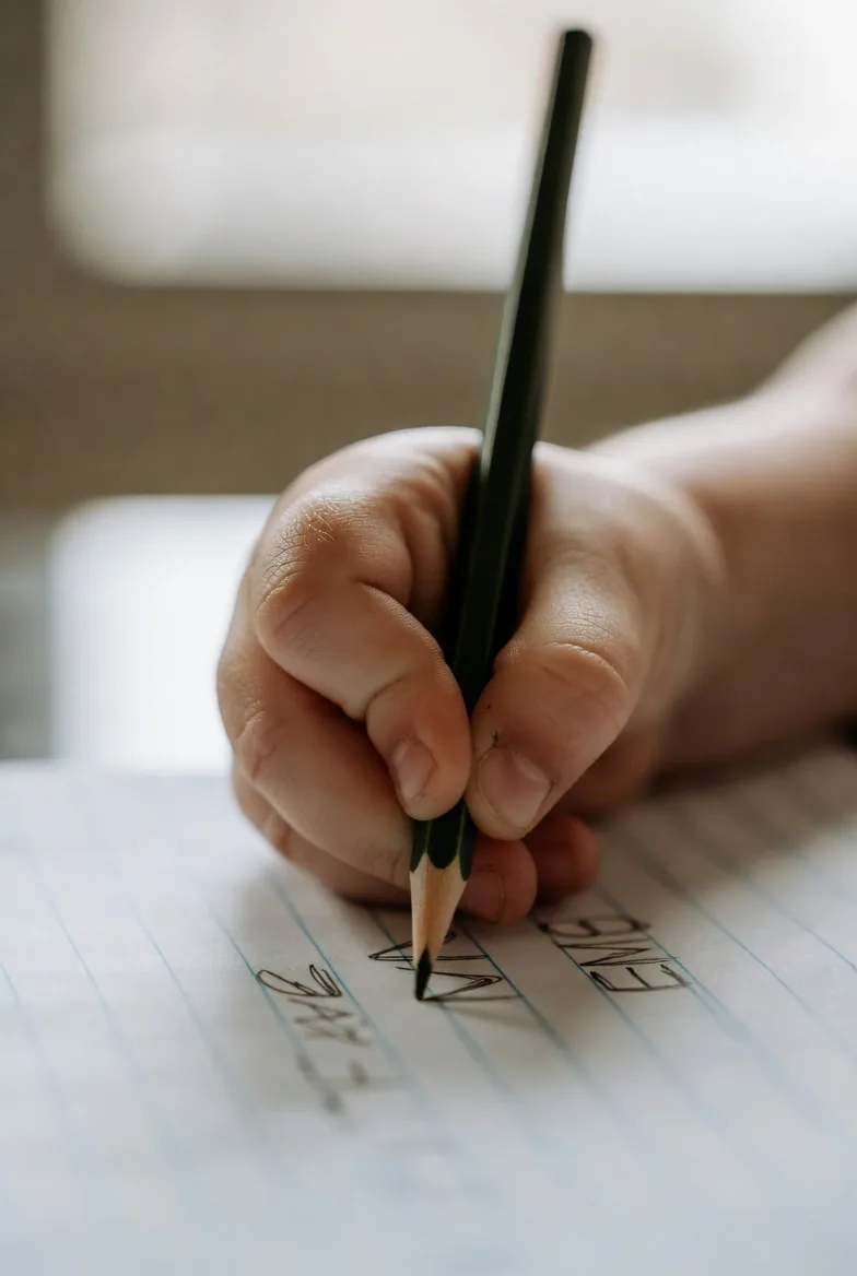 A hand writing carefully on lined paper